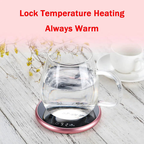 Electric Mug Warmer With Adjustable Temperature And Smart Touch Control, Auto Shut Off Timer Keeps That Morning Brew Piping Hot, Premium Silver Aluminum Alloy Desk Cup Heater For Work Or Chill with a glass kettle on a warming pad.