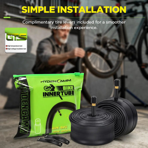 Two Pack 26x1.75-2.125 Butyl Bike Tubes With 35mm Schrader Valve Built For MTB Cruisers City And Road Bikes Includes Two Tire Levers Ready To Roll Spare Set For 26 Inch Tires package, tubes, and tire levers displayed in front of bike being repaired.