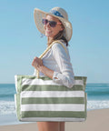 Woman at beach carrying Ultra Roomy Waterproof Beach Tote For Women With Secure Zipper Closure Large Sandproof Swim Pool Bag