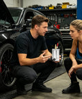 Man and woman discussing 300Ml Double Port Oil Catch Can Kit With Innovative Baffle Plate Design in garage setting.