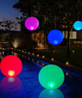 Solar Powered Floating Ball Pool Lights Four Pack 14 Inch Inflatable Hangable LED Glow Globes IP68 Waterproof Rechargeable Color Changing Lights illuminating a pool at night.