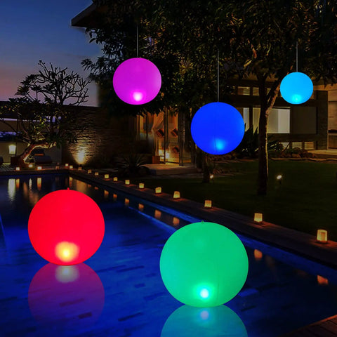 Solar Powered Floating Ball Pool Lights Four Pack 14 Inch Inflatable Hangable LED Glow Globes IP68 Waterproof Rechargeable Color Changing Lights illuminating a pool at night.