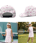 Girl in pink girls athletic dress with UPF 50 plus sun shield, matching bow hat, holding a tennis racket and ball, sleeveless outfit.