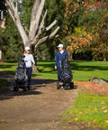 All Terrain Electric Golf Cart With Full Directional Remote Control Smart Compact Fold Design Complete Accessory Bundle For A Top Shelf Smooth Operator Ride, couple using carts on path.
