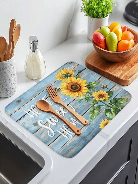 MustHave Kitchen Dish Drying Mat 18x24 with sunflower bee design on blue wood grain, on countertop with utensils