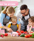 Toddler toy knife set with pink utensils and cutting board on kitchen table with vegetables