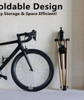 Folded Beefy Pro Grade Aluminum Bike Repair Stand next to bike for easy storage, focus on foldable design, space efficient.