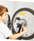 Child installing Mechanical Bike Disc Brake Kit Front And Rear Upgrade With 160mm Rotors on a bicycle wheel.