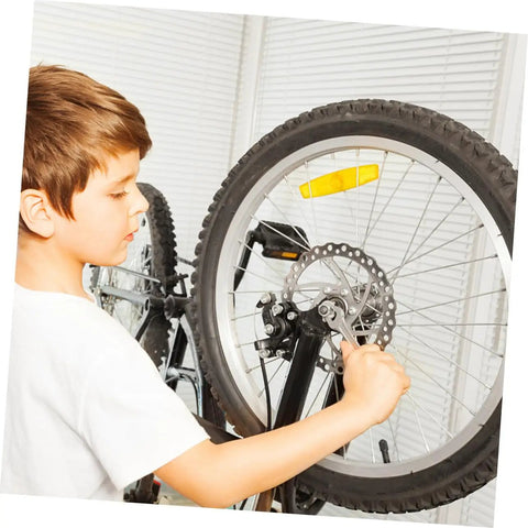 Child installing Mechanical Bike Disc Brake Kit Front And Rear Upgrade With 160mm Rotors on a bicycle wheel.