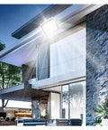JUDYSSY Solar Outdoor Courtyard Lights 5-in-1 Led Beads High-Power Floodlights illuminate a modern house exterior at night.