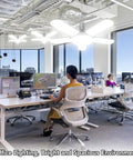 Modern office with LED ceiling lights, open workspace, and large windows providing natural daylight