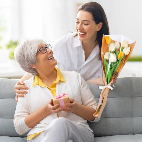 Woman gifting tulips in 50 Pack Flower Wrapping Bags For Bouquets, Kraft Paper Floral Packing Sleeves, 9.8x3.9x17.9 Inch to an elderly woman.