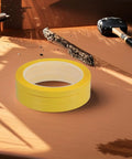 Four Pack Yellow Heat Resistant Paper Tape featuring a dang tough hold on a wooden desk with tools, ideal for neat labeling and organizing.