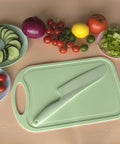 11 Inch Plastic Lettuce Knife With Serrated Blade To Keep Greens Kickin Fresh And Block Browning, Nonstick Safe For Cutting Cakes Fruits Bread, No Sweat Cleaning Dishwasher Ready Duo Pack In Crisp Green on a cutting board with fresh vegetables.