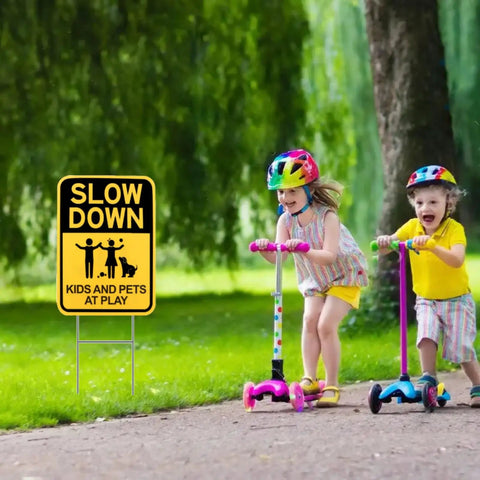 Slow Down Signs With H Stake 16x12 Inches Kids And Pets At Play Double Sided Street Safety Signs in use by sidewalk with children playing.