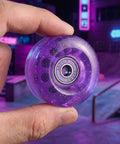 82A Purple Glitter Quad Roller Skate Wheels Four Pack For Indoor Outdoor Use, close-up of one wheel held in hand showing details.