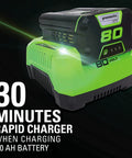 80V Brushless Cordless Chainsaw With 18 Inch Bar And Smart Auto Oiler Built For No Sweat Backyard Cleanup And Quick Branch Trimming Featuring Rapid Snap Tension Dial And Slick Gas Free Cutting Action For Serious Yard Maintenance Jobs charger with green and black design.