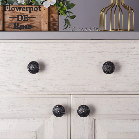 Rock Solid 8 Pack Oil Rubbed Bronze Cabinet Knobs Featuring Heavy Duty Floral Details For Rustic Kitchen Cabinetry And Dresser Drawers Finished In Antiqued Bronze on white drawers.