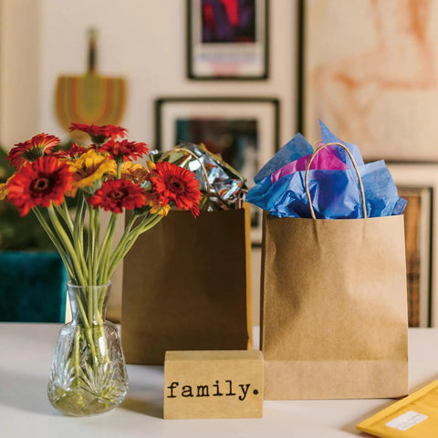 Brown Paper Bags With Handles 8x4.25x10.5 Inches Medium Gift Bags Bulk 100 Pack Recycled Kraft Paper Eco Friendly Shopping Bags decorated with colorful tissue paper.
