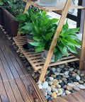 Indoor garden display with 5 Lb Mixed Color River Pebbles 2 to 3 Inch Large Polished Stones for Indoor Plants and wooden shelving.