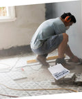 Worker using tools with Heavy Duty Toggle Bolt And Wing Nut Kit for drywall, 48 piece set visible on floor.