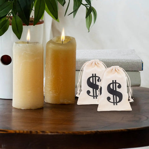 Beige Cotton Drawstring Gift Pouches With Money Sign For Cowboy Party Decor And Birthday Party Favors, next to candles