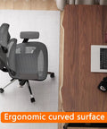 Level Up Your Home Office Game With This Rock Solid 55 Inch Manual Standing Desk Packed With A Pull Out Keyboard Tray And Four Easy Height Adjustments So You Can Switch Between Sitting And Standing Without Breaking A Sweat, showing a curved surface and ergonomic chair.