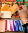 Hands arranging diverse cards from Color Card Deck For Creators Break Free From The Color Wheel With 200 Coordinated Cards.