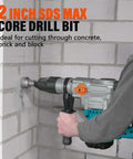 Side view of Berserker 2in x 9in SDS Max core drill bit on a rotary hammer drilling into a concrete block wall