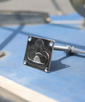 Close-up of a MIZUGIWA stainless steel large flush hatch latch with back plate on blue deck.