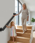 Heavy Duty Carbon Steel Wall Mounted Stair Railing With Super Grippy Non Slip Handrail For Indoor Outdoor Steps And Hallways, shown in use by two people.