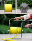 Heavy Duty Retractable Garden Hose Reel Stainless Steel Water Hose Cart with yellow hose and brass fittings, user winding hose.