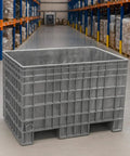 Dang Tough Heavy Duty Plastic Bulk Storage Tote, 42X29X28 Inch in gray, shown in a warehouse setting, ideal for heavy loads.