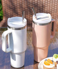Two large handle tumblers with 12 Inch Stainless Steel Straws Replacement Set, Four Pack With Cleaning Brush, on outdoor table.