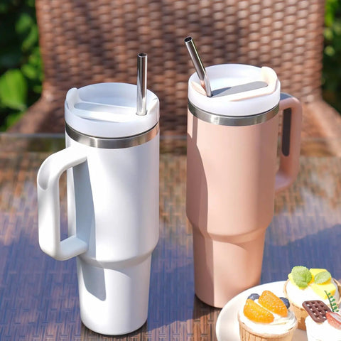 Two large handle tumblers with 12 Inch Stainless Steel Straws Replacement Set, Four Pack With Cleaning Brush, on outdoor table.