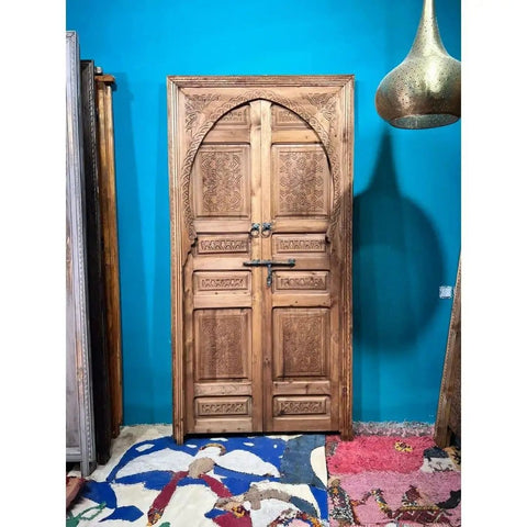 Decorative wooden door against blue wall, intricate carving; "Handcrafted Barn Door In Your Size Dope Sliding Or Hinged Interior Exterior Front Door With That Vintage Meets Modern Farmhouse Vibe Made To Order 71 By 34 Inches No Glass Or Hardware Included Customizable" focus keyword.