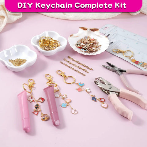 All In One Lip Gloss Keychain Making Kit With 100 Enamel Charms, clips, chains, pliers, hole punch and tubes on table