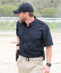 Men's Short Sleeve Tactical Shirt In LAPD Navy Blue With Teflon Stain Repellent Finish worn with khaki pants outdoors.