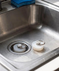 Silicone Drain Stopper for Kitchen Sinks and Bathtubs, White in a stainless steel sink with a cleaning sponge.