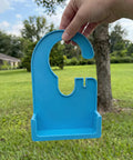 Hand holding a blue Pump Holder For Enteral Feeding Pump No Tools Needed Snap Fit 3D Printed Carrier Stand outside.