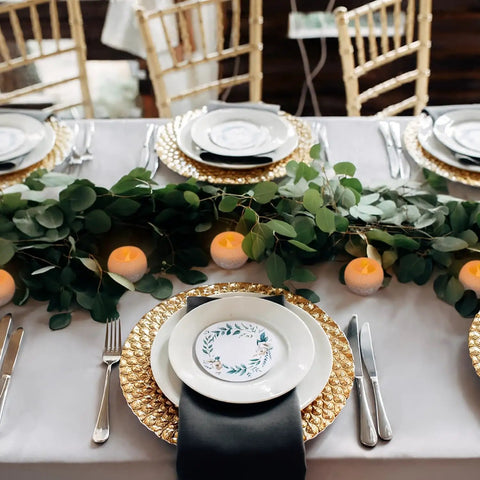 Table with Small Real Wax Flameless Candles with Silver Glitter, LED Flicker, 3 Pack, used as centerpiece with greenery and plates.
