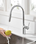 SUMERAIN Kitchen Faucet with Pull Down Sprayer Dual Mode Brushed Gold shown washing a pear in modern kitchen sink.