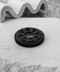 32P 0.8 Mod 57T Carbon Steel Spur Gear for Arrma 1/10 3S RC Cars on a stone slab