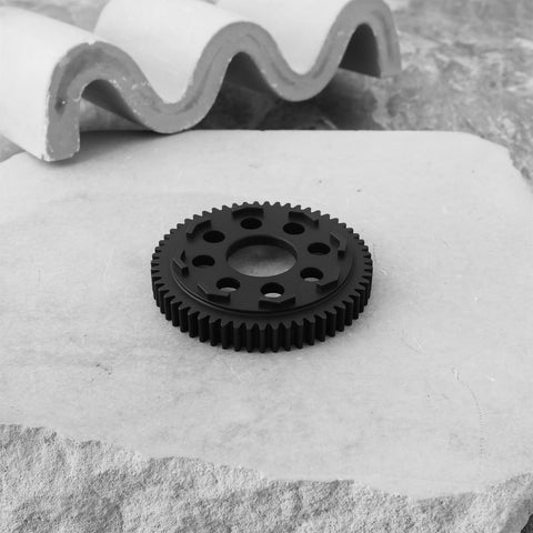 32P 0.8 Mod 57T Carbon Steel Spur Gear for Arrma 1/10 3S RC Cars on a stone slab