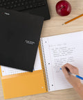 Hustle Ready Black Spiral Notebook With Five Subject Sections And College Ruled Paper Providing Clean Lines And No Bleed Pages Built For Daily Study Grinds And Phone Pairing on wooden desk with pencil and apple.