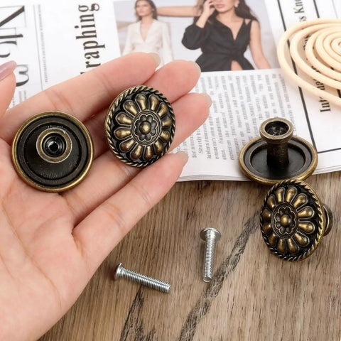Eight Piece Vintage Antique Brass Knob Set With Flower Pattern For Cabinets, Drawers, And Doors shown in hand, screws nearby.
