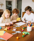Children using durable 1/4 Inch single hole puncher with 8-sheet capacity for crafts, surrounded by colorful paper and stationery.