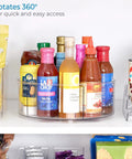 Recycled Plastic Lazy Susan Spin Turntable Organizer For Pantry And Bathroom Space-Saving Go-To Storage Solution For Kitchen Cabinets Drawers And General Organization 11.5 Inch Clear, holding assorted sauce bottles on a shelf.