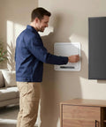 Person installing Ultra Slim In Wall Media Box with hassle free cable routing in living room, featuring white shell and TV nearby.