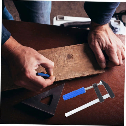 Man using 4Pcs Woodworking Clamps Set For Quick Fixing And Boss Grip Heavy Duty Carpentry Clips on wooden board in workshop.